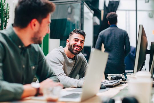 Due ragazzi chiacchierano amichevolmente in un internet café.